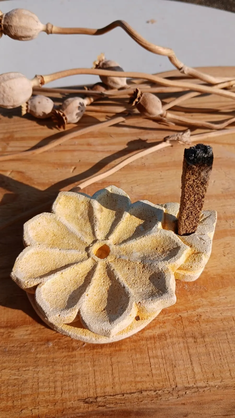 Porte-encens en forme de fleur, une barrette d'encens fumant plantée sur le côté